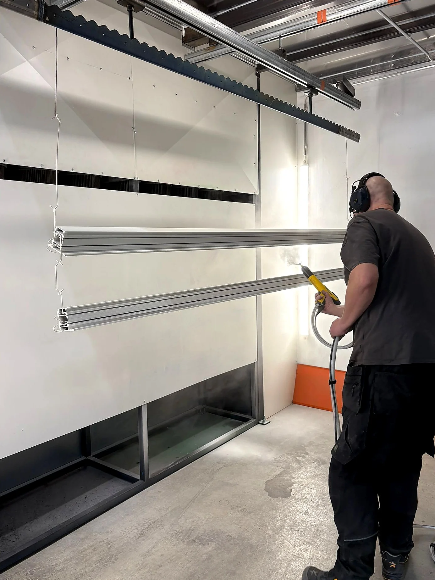 Long metal profiles being powder coated