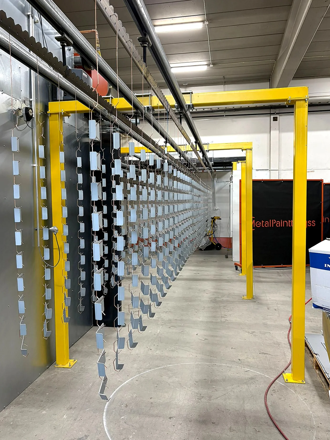 Light powder coating parts hanging in the conveyor line