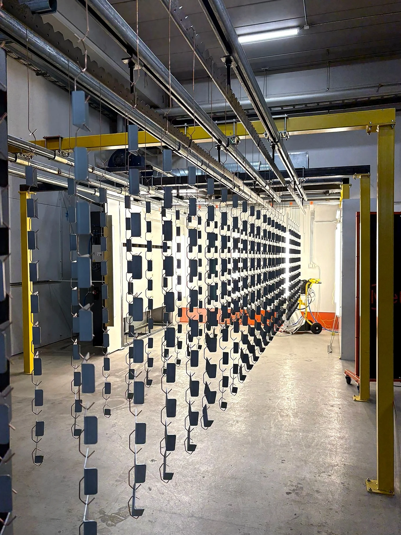 Powder coated components hanging in the line